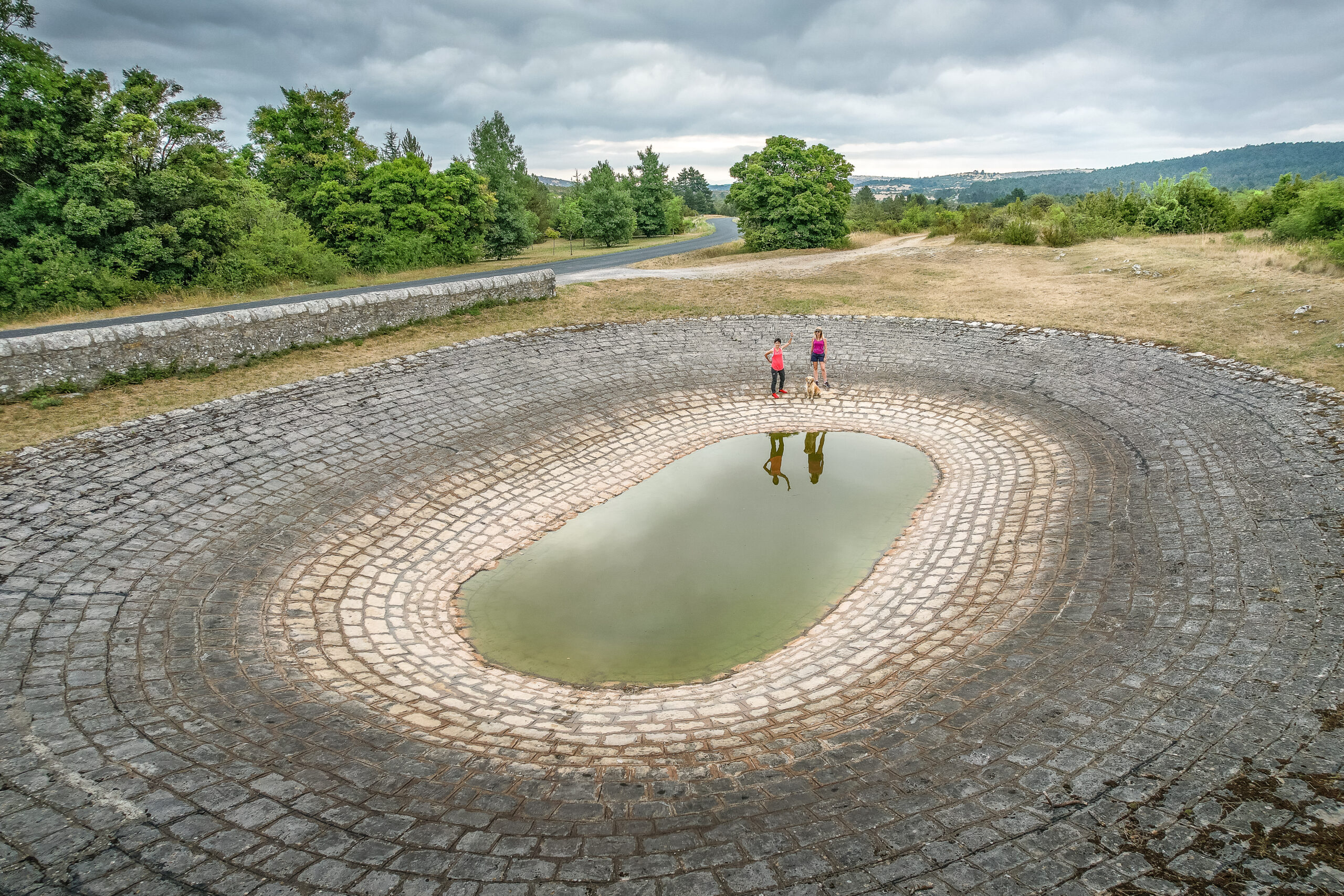 Lavogne traditionnelle en pierre remplie d’eau sur le plateau du Larzac.