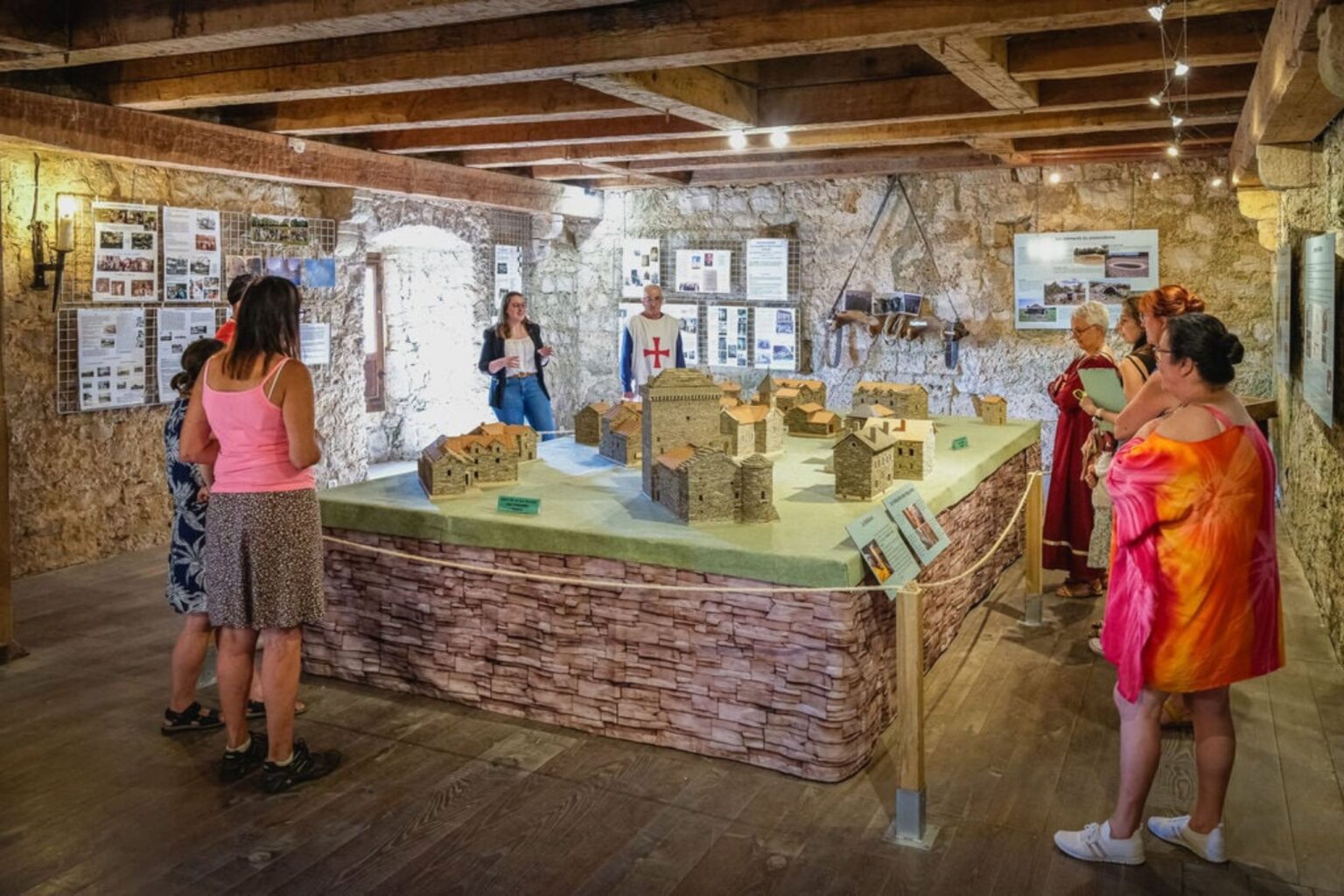 Visiteurs observant une maquette du village lors d’une visite guidée à la Tour du Viala-du-Pas-de-Jaux.