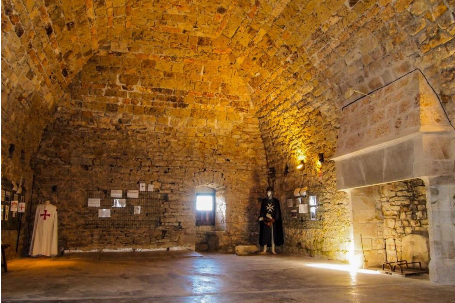 Salle voûtée en pierre avec cheminée monumentale et expositions historiques à la Tour du Viala-du-Pas-de-Jaux.