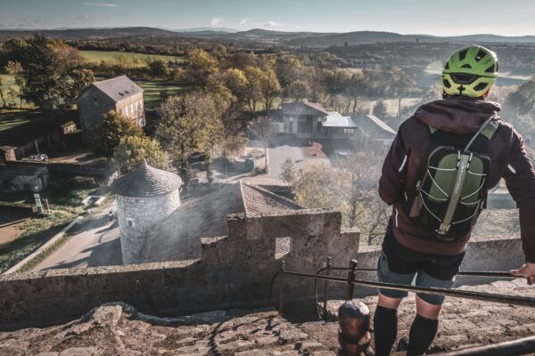Cycliste observant la vue panoramique depuis la Tour du Viala-du-Pas-de-Jaux sur les paysages du Larzac.